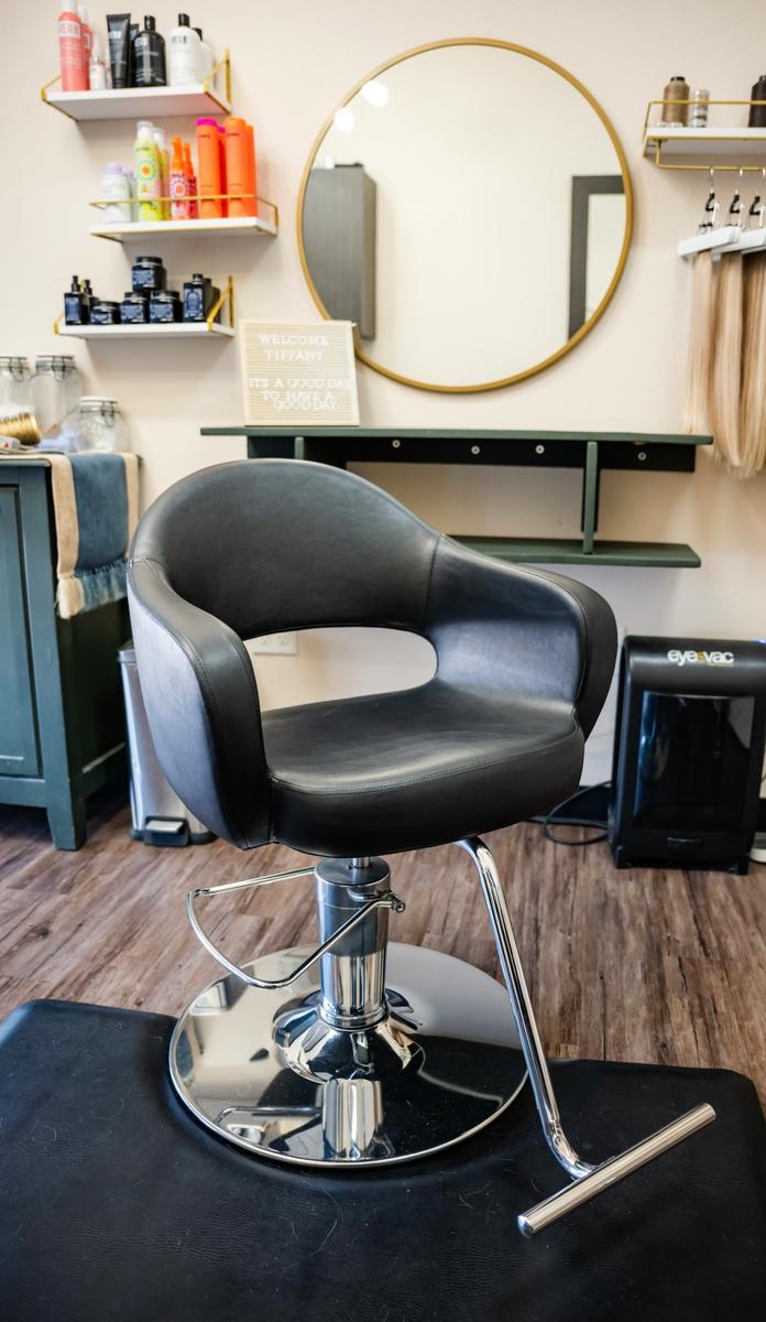 Empty salon chair at a salon station to show the vibe of the salon in Plano, TX.